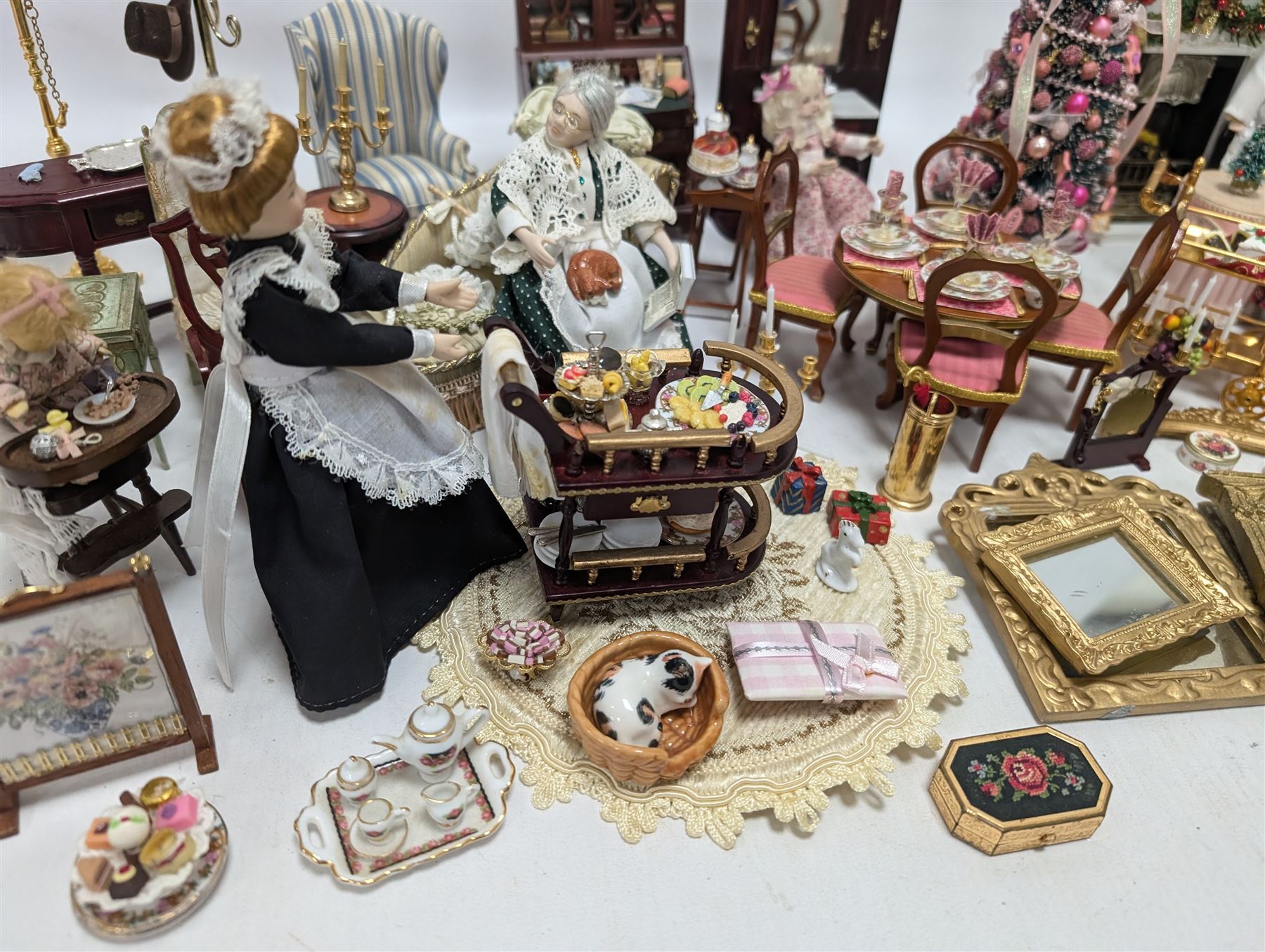 Dolls house living room and ding room furniture, including sofa, chair, long case clock, Christmas trees, fireplace, dresser, chairs, tables, mirrors, seven figures and a collection of predominantly Christmas themed decorations, food, etc