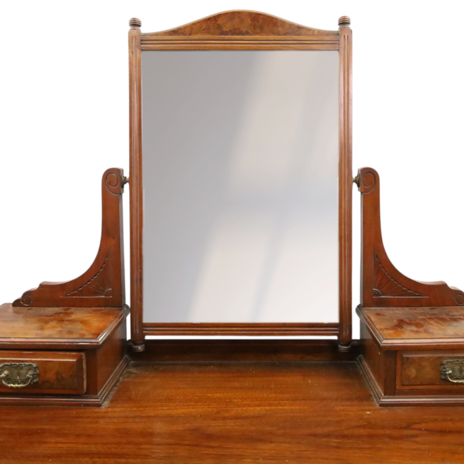 Late Victorian figured walnut and mahogany dressing table, raised swing-mirror back over trinket drawers, fitted with two drawers with brass Aesthetic Movement handles, on ring-turned supports with ceramic castors