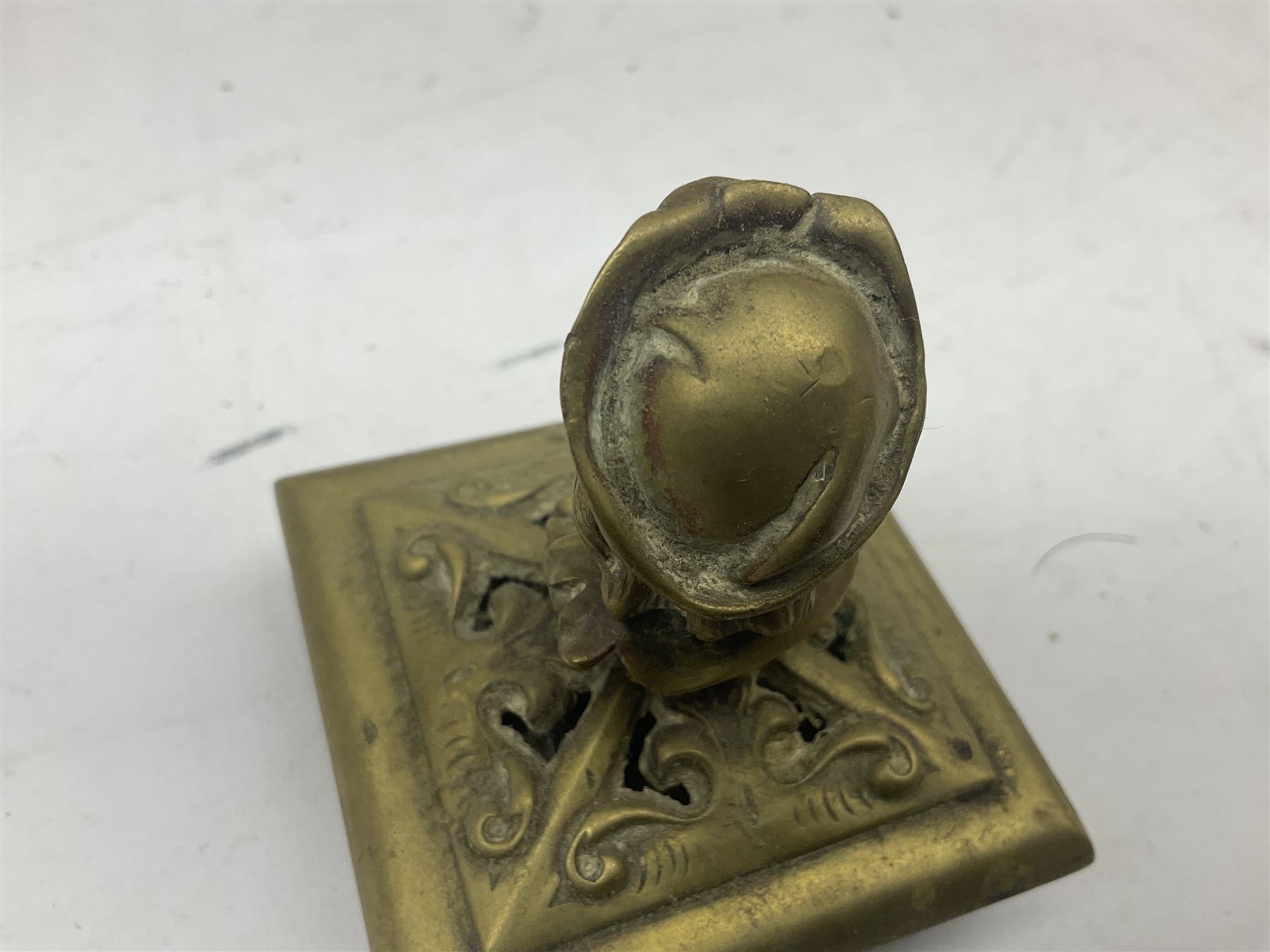 Collection of victorian and later brass desk accessories, to include a letter holder with cherub design, ink well of square form with hinged lid, brass table bell, brass casket with relief decoration, etc  