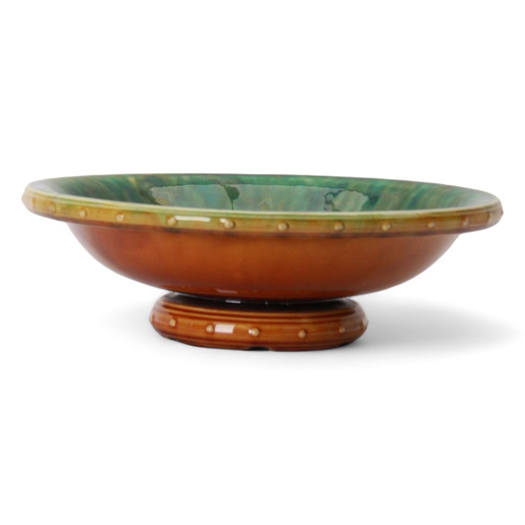 Christopher Dresser for Linthorpe; pedestal bowl, glazed brown to the exterior, the interior in blues and greens, with impressed mark 451 beneath, H8cm, D25cm