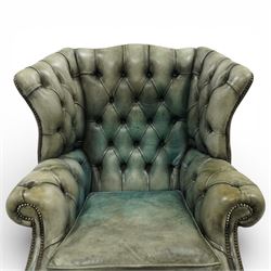 Georgian design mahogany framed wingback armchair, upholstered in rustic pale green buttoned leather with loose seat cushion, raised on square supports united by H-stretcher