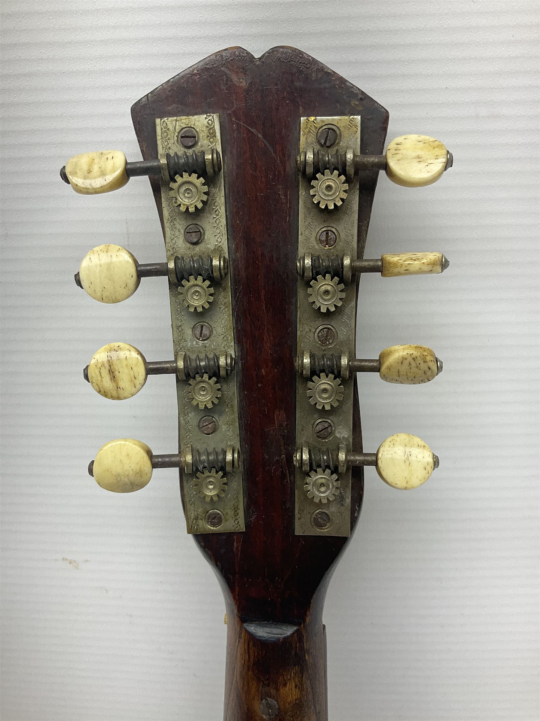 Late 19th century Italian lute back mandolin with segmented bowl back, bears label Gennaro Maglioni Napoli L61cm; in ebonised wooden case; together with another similar damaged Italian lute back mandolin for restoration or spares (2)