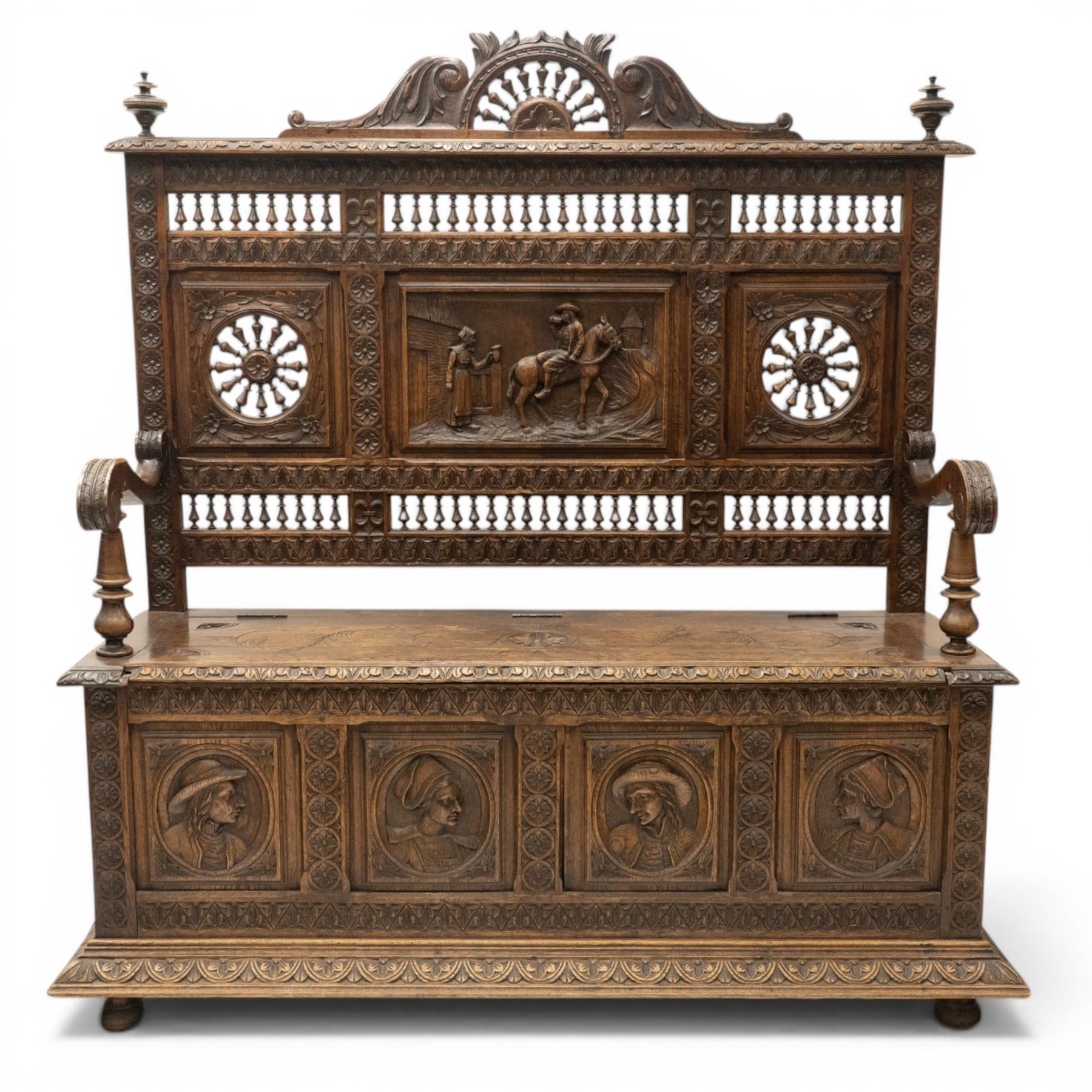 19th century European heavily carved oak hall settle, the impressive high-back with a pierced and carved acanthus pediment, over foliate and rosette carved back rails, flanking a central panel depicting a gentleman on horseback drinking, the hinged box seat over a quadruple panelled front with relief carved busts, lower moulded and carved edge on compressed bun feet