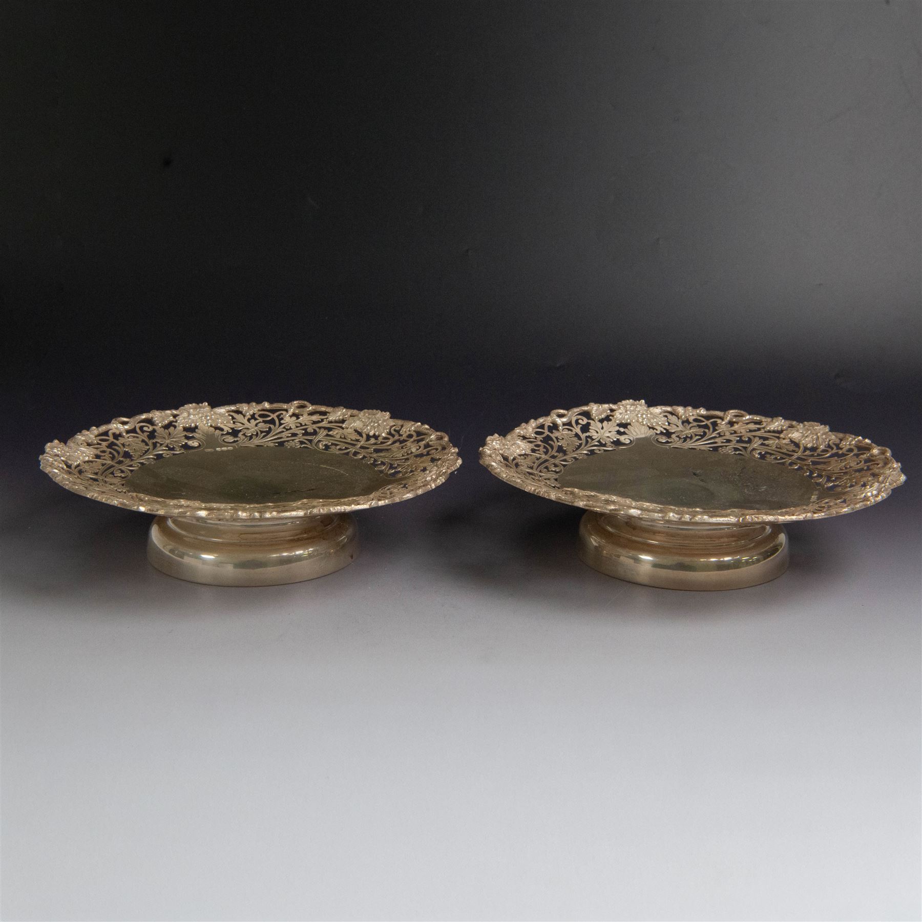 Pair of 1930s silver pedestal dishes, of circular form, the sides with pierced vine decoration, upon a domed pedestal foot, hallmarked Lee & Wigfull, Sheffield 1938, D21cm, H6cm