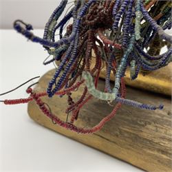 Victorian bead and wire model of a parrot, of polychrome beads, with glass eyes, on a wooden base, H24cm