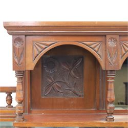 Edwardian walnut overmantel mirror, moulded cornice over three arched apertures with turned supports, flanked by open shelves with turned uprights and finials, carved foliate panels to the base