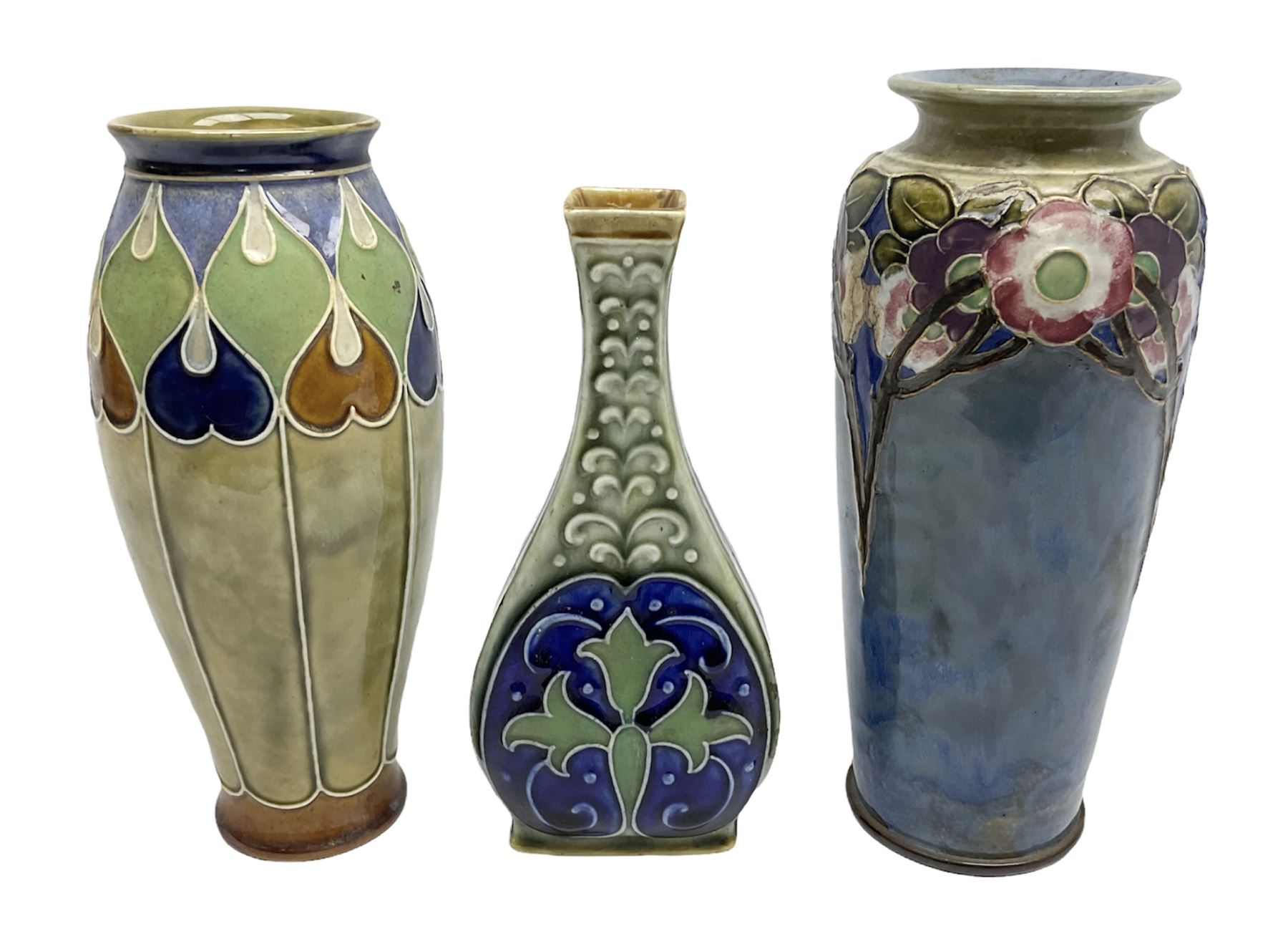Two Royal Doulton stoneware vases, the first example with tubelined floral decoration, the second with Art Nouveau decoration, together Doulton Lambeth vase of flattened form with foliate decoration on a green ground, all with impressed mark beneath, tallest example H26cm