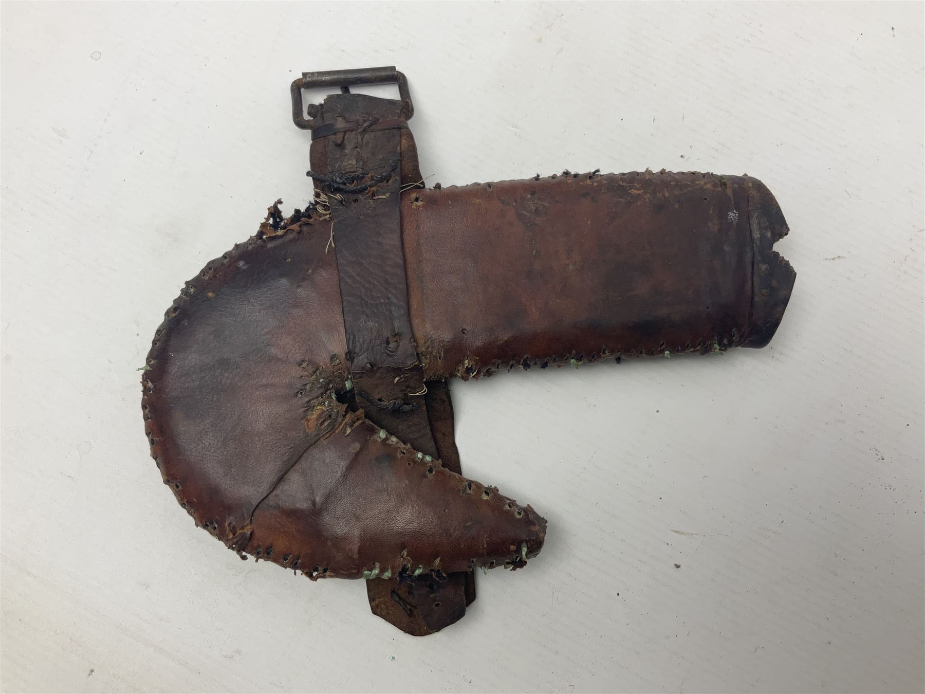 Eastern Jambiya, the 19cm double edge steel blade with raised medial ridge, waisted horn grip with pique work and white metal band; in stitched leather scabbard L33cm overall
