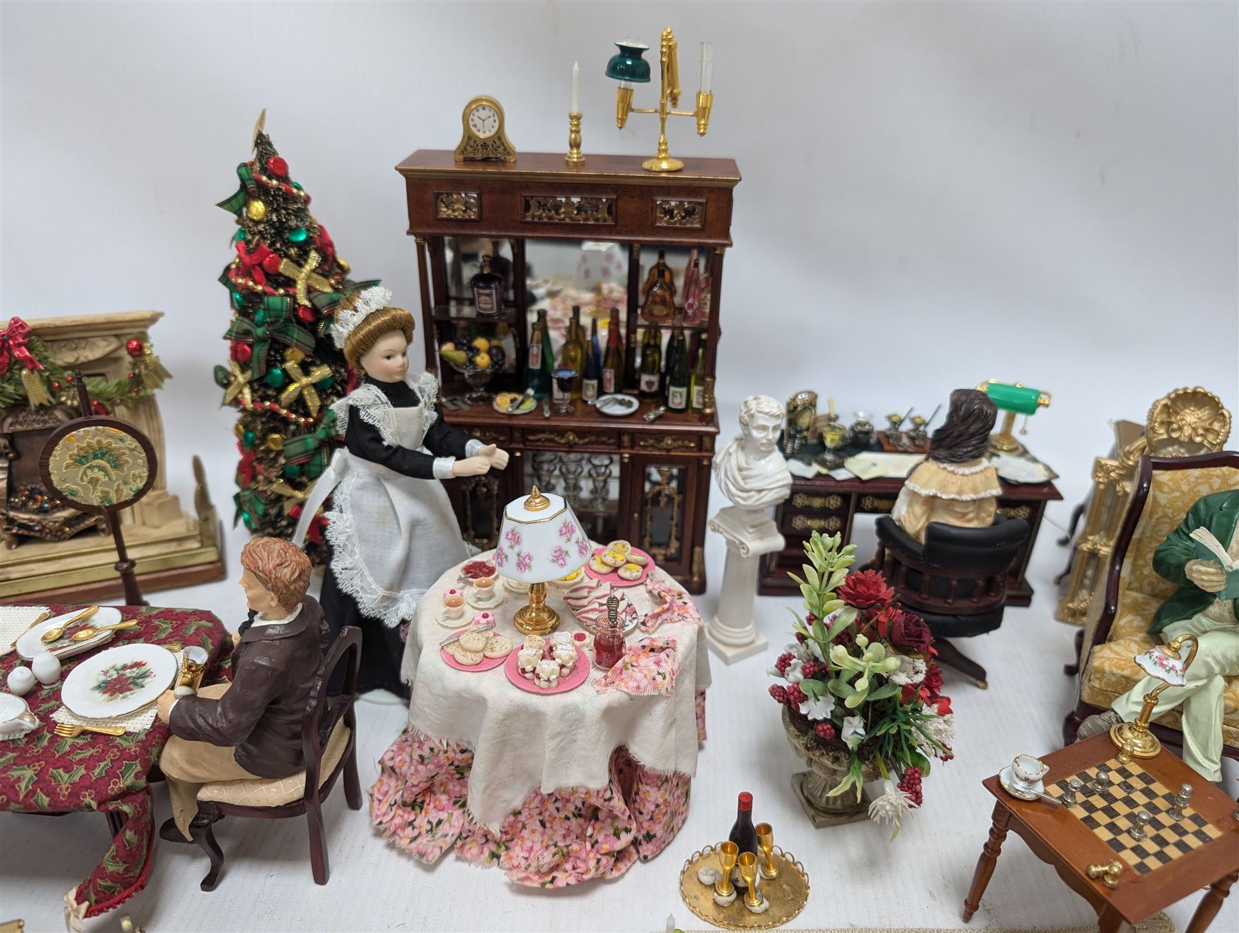 Dolls house living room and dining room furniture, including arm chairs, desk, fireplaces, dressers, tables, eight figures and a large collection of predominantly Christmas themed food, accessories and decorations