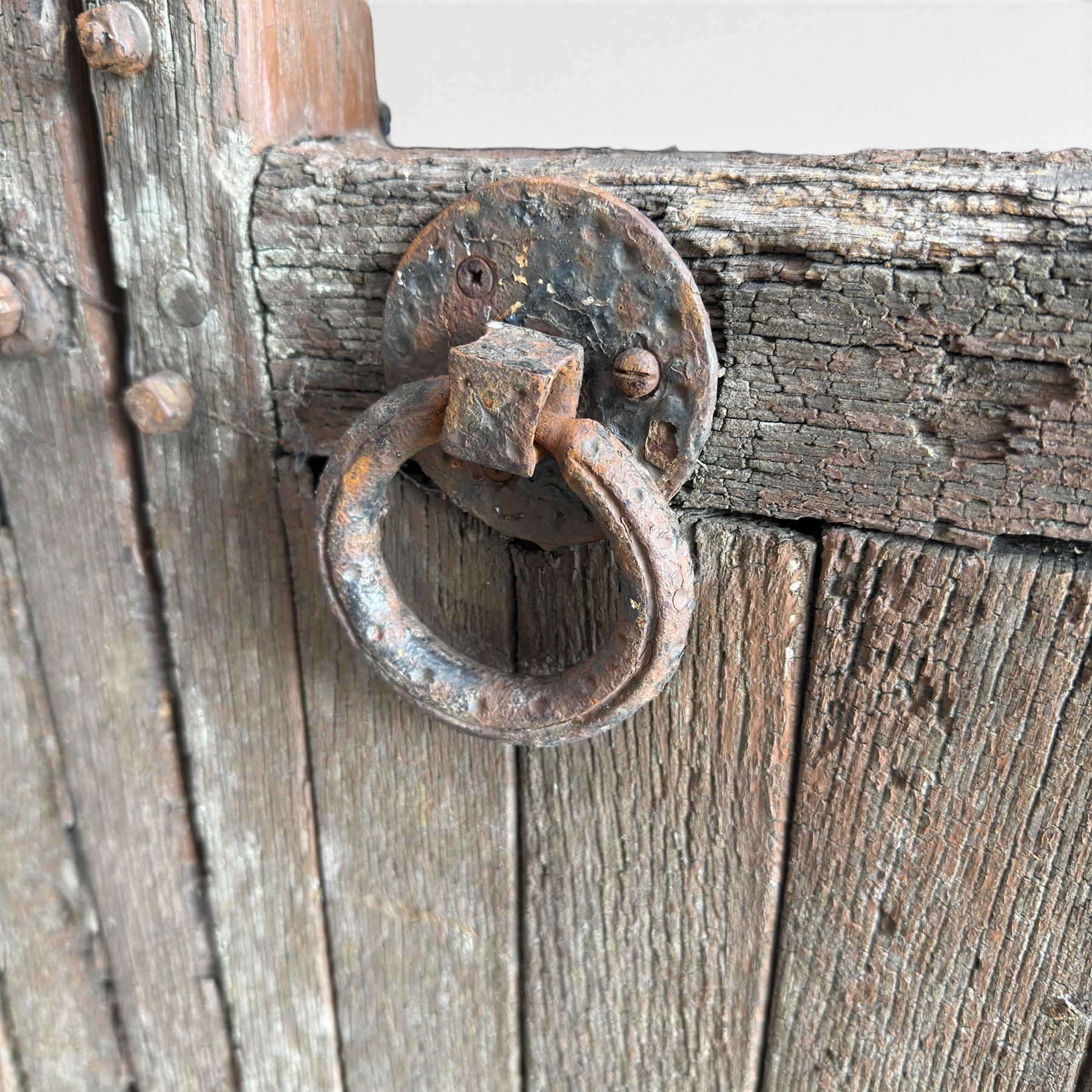 Pair of 19th century weathered wooden ecclesiastical church gates, the cresting rail over four pierced arches with slatted lower section, fitted with heavy cast iron hinges, latch and fittings