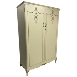 French classic design cream painted double wardrobe, the doors decorated with gilt and cream applied urn motifs with extending bell-flower festoons and ribbon twists, enclosing shelf and hanging rail, shaped apron on acanthus cabriole feet