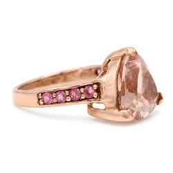 9ct rose gold morganite and tourmaline ring, single trilliant cut morganite of approx 5.35 carat, each shoulder set with four round cut tourmalines, Birmingham 2011