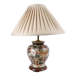 Japanese ceramics table lamp, decorated with flowers and butterflies upon a circular woode...