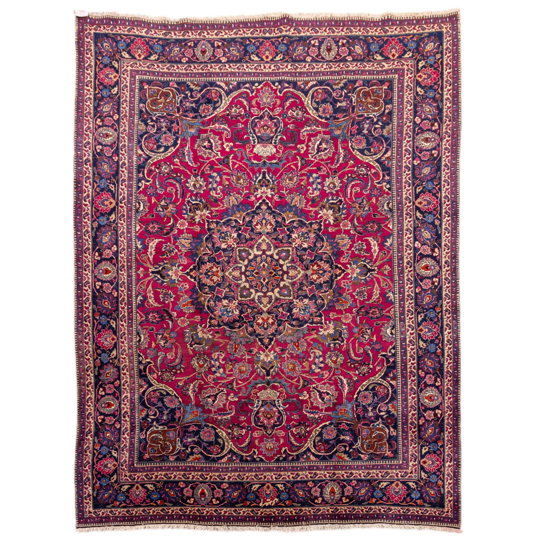 North East Persian Mashad hand-knotted carpet, rich madder red field with central cusped foliate medallion with issuing scrolling arabesques, palmettes, and floral sprays, enclosed within a broad indigo main border of bold palmettes, between multiple guard stripes, with cotton fringe ends 