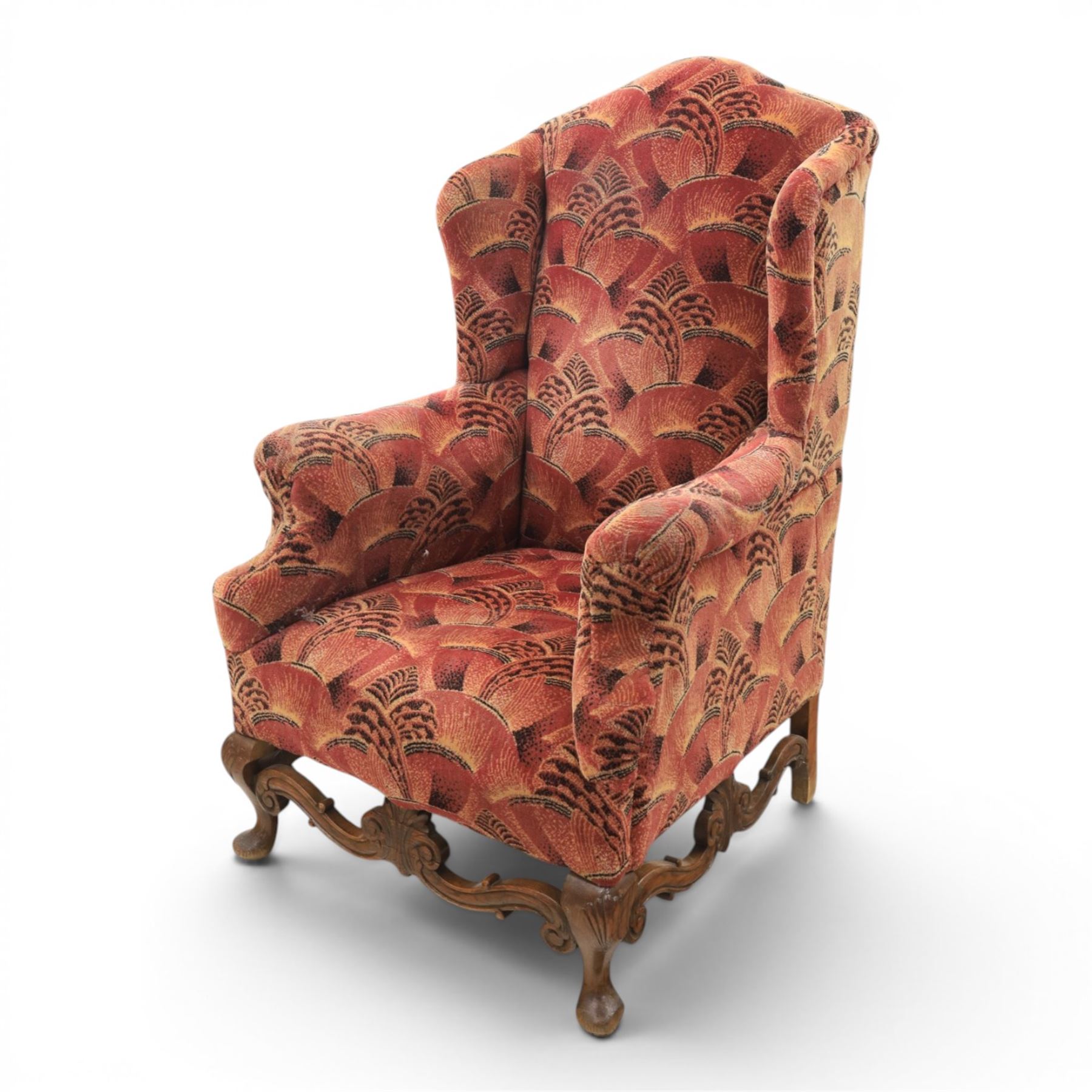 Large upholstered wingback chair, crimson geometric upholstery, carved front apron raised on cabriole supports 