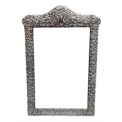 Early 20th century continental silver mounted dressing table top mirror, of rectangular form, the frame embossed with vacant reserve, lattice work, flower heads and C scrolls, with easel style support verso, unmarked but tests as silver, overall H49.5cm W31.5cm
