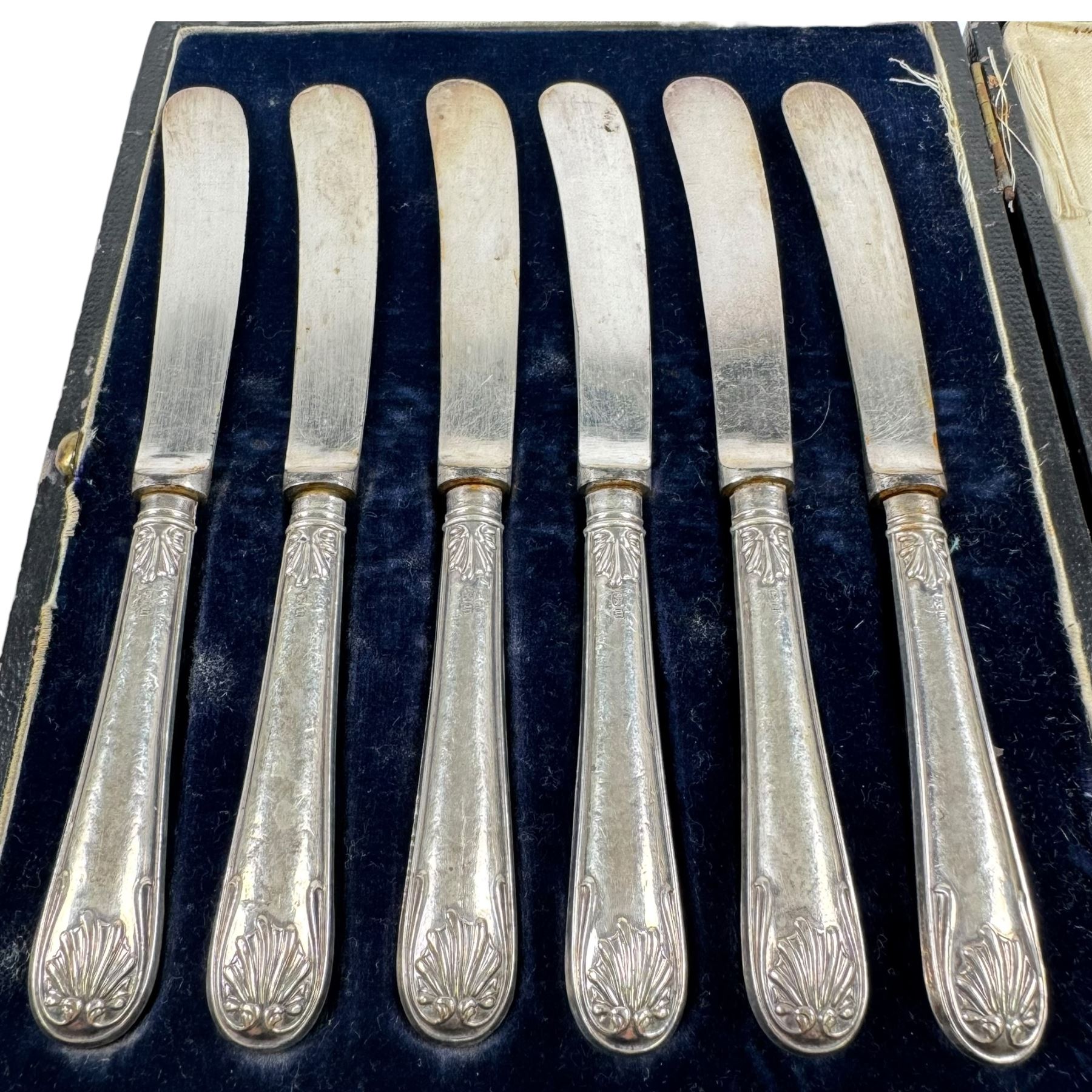 Two sets of cased silver handled tea knives, two silver mounted photo frames, silver mounted candlestick, silver ring holder with weighted base, silver mounted jewellery box