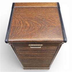 Early 20th century oak tambour front fitted cabinet, rectangular top with rounded corners over a roll tambour front enclosing a fitted interior of multiple shallow drawers with cut-out pulls, the sides with rounded uprights, on a stepped plinth base