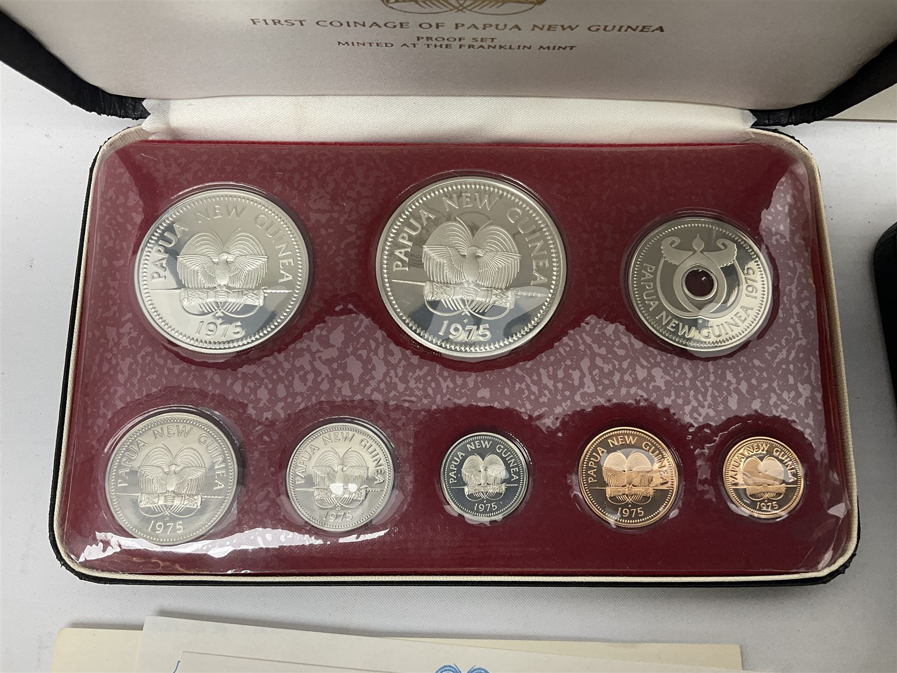 Four Papua New Guinea proof eight coin sets, from ten kina to one toea, comprising First Coinage of Papua New Guinea 1975 proof set, 1976, 1977, and 1979 proof sets, the 1977 and 1979 sets containing 925 silver ten kina and 500 silver five kina coins, all minted at the Franklin Mint, cased with certificates (4)