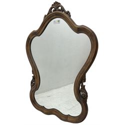 French design stained beech framed wall mirror, shaped and moulded framed with scrolling foliage carved pediment and brackets, plain mirror plate 