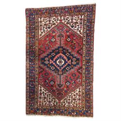 Persian Heriz crimson ground carpet, the central navy geometric medallion on a red crimson...