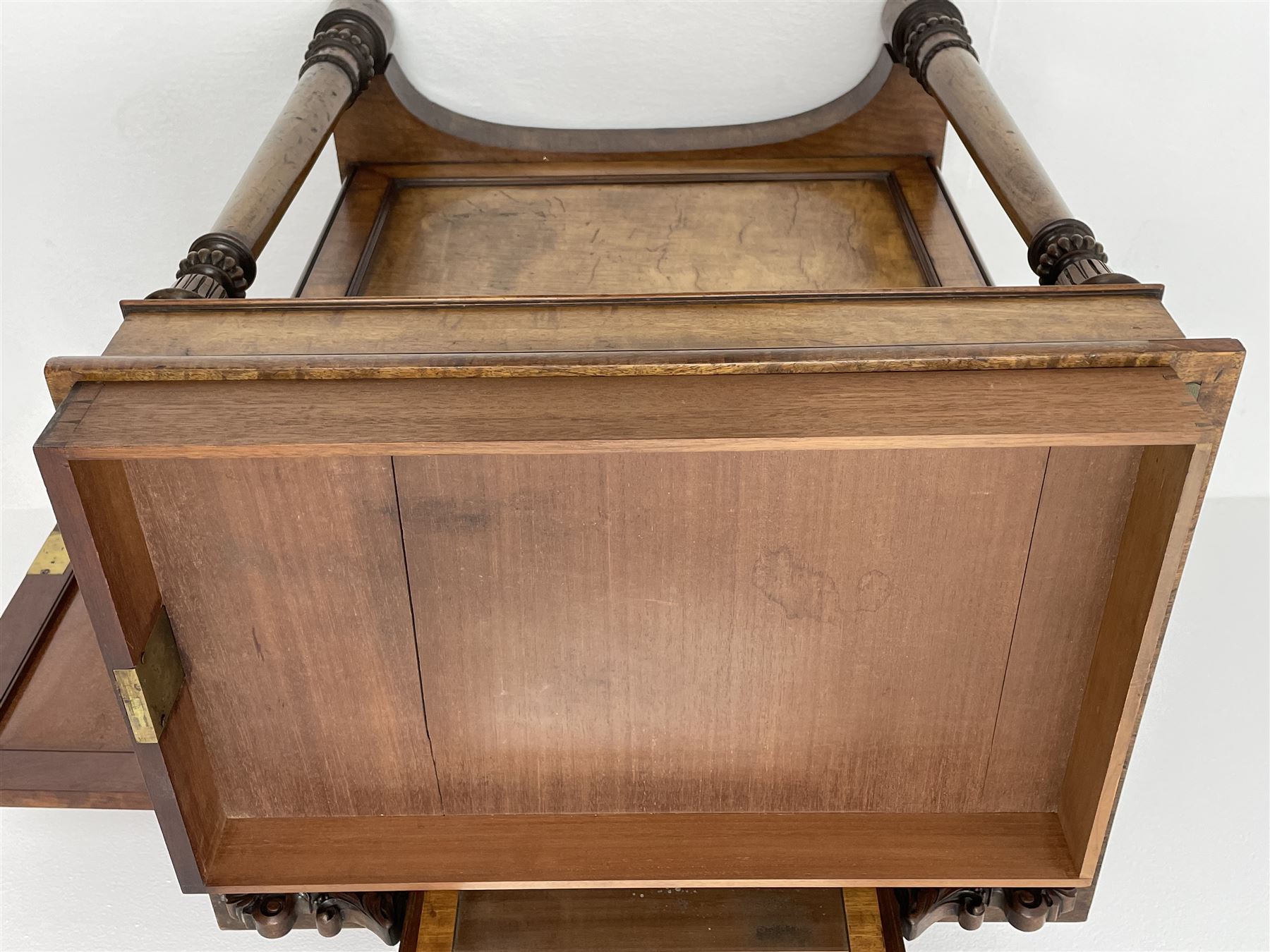 Early Victorian figured mahogany dressing cabinet, the raised shell and scroll carved back lifts to reveal rectangular easel mirror with mahogany band, flat rectangular top with tooled leather inset, slide at each side with matching leather inset, full width drawer above cupboard enclosing a series of five drawers, turned front supports, panelled front, sides and back