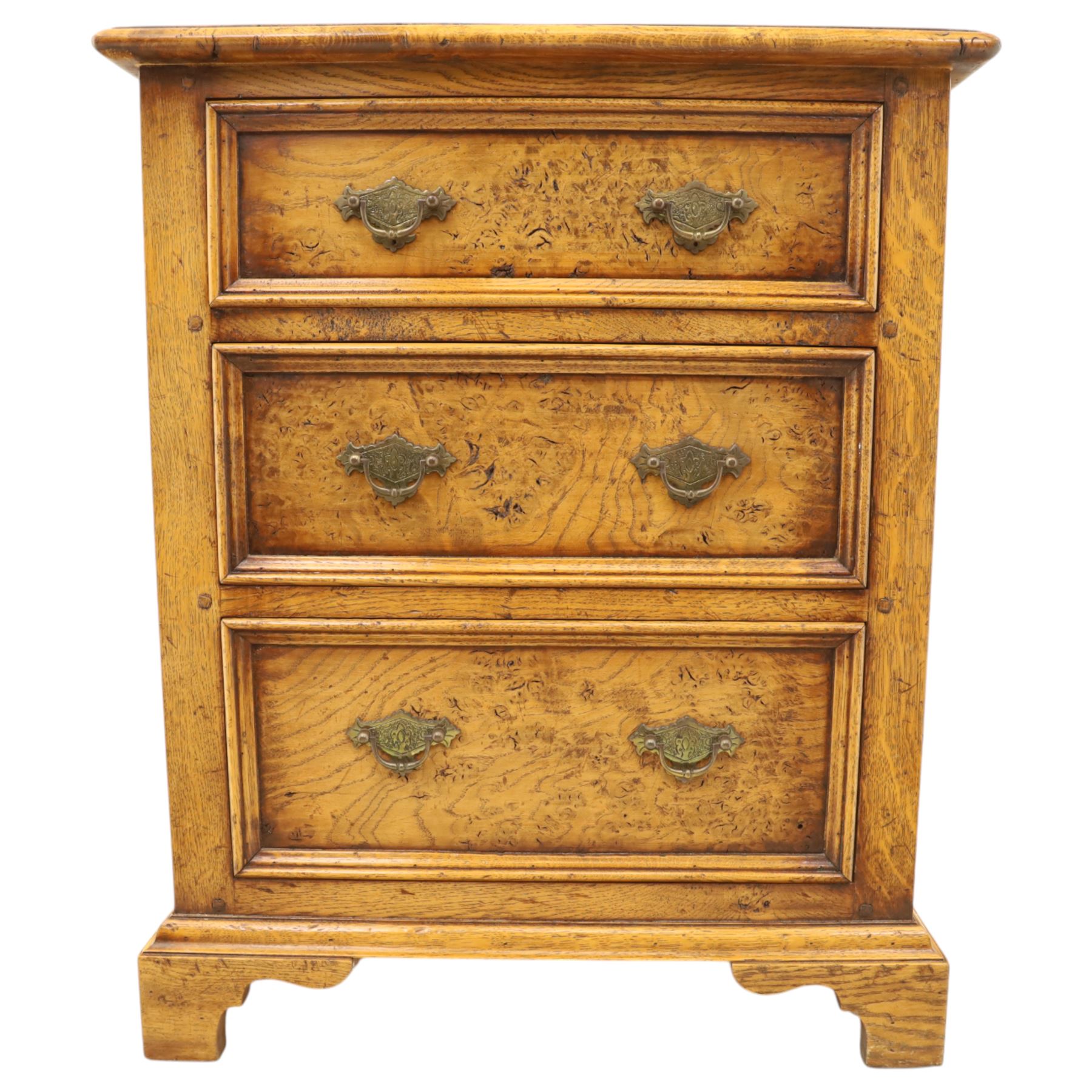 Small 20th century burr oak chest, the figured top over three graduated drawers with moulded fronts and pierced brass handles, on shaped feet