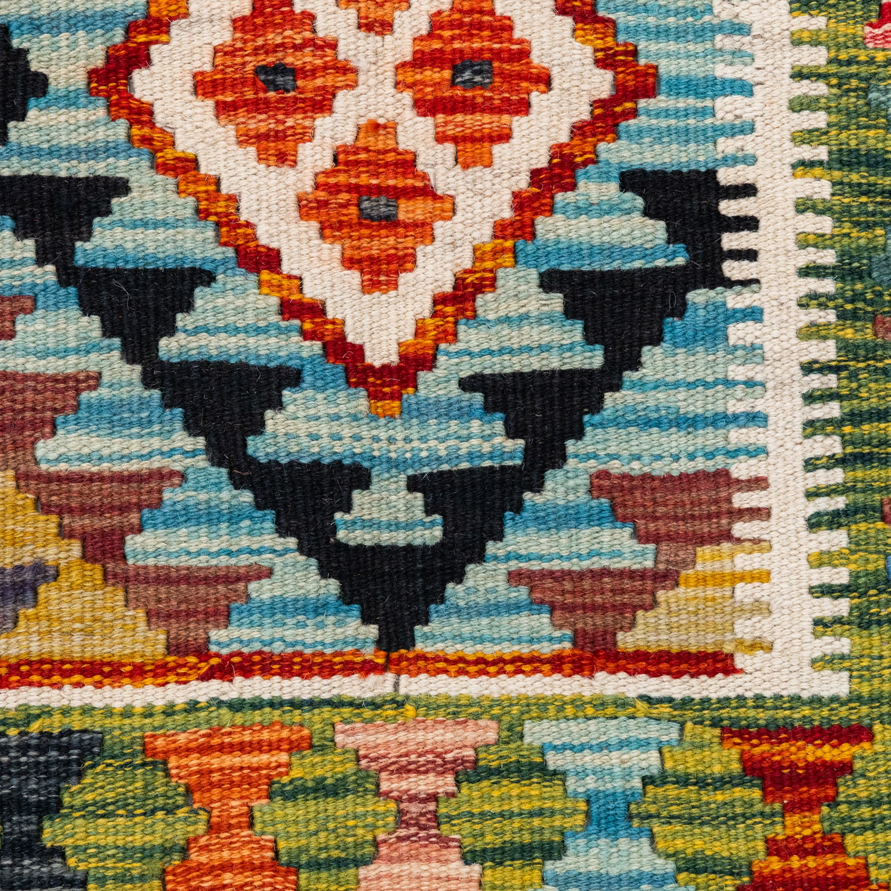 Afghan kilim cyan ground rug, the field with repeating lozenges containing geometric amber and ivory motifs with dark indigo borders, the citrine border with further geometric designs of contrasting tones