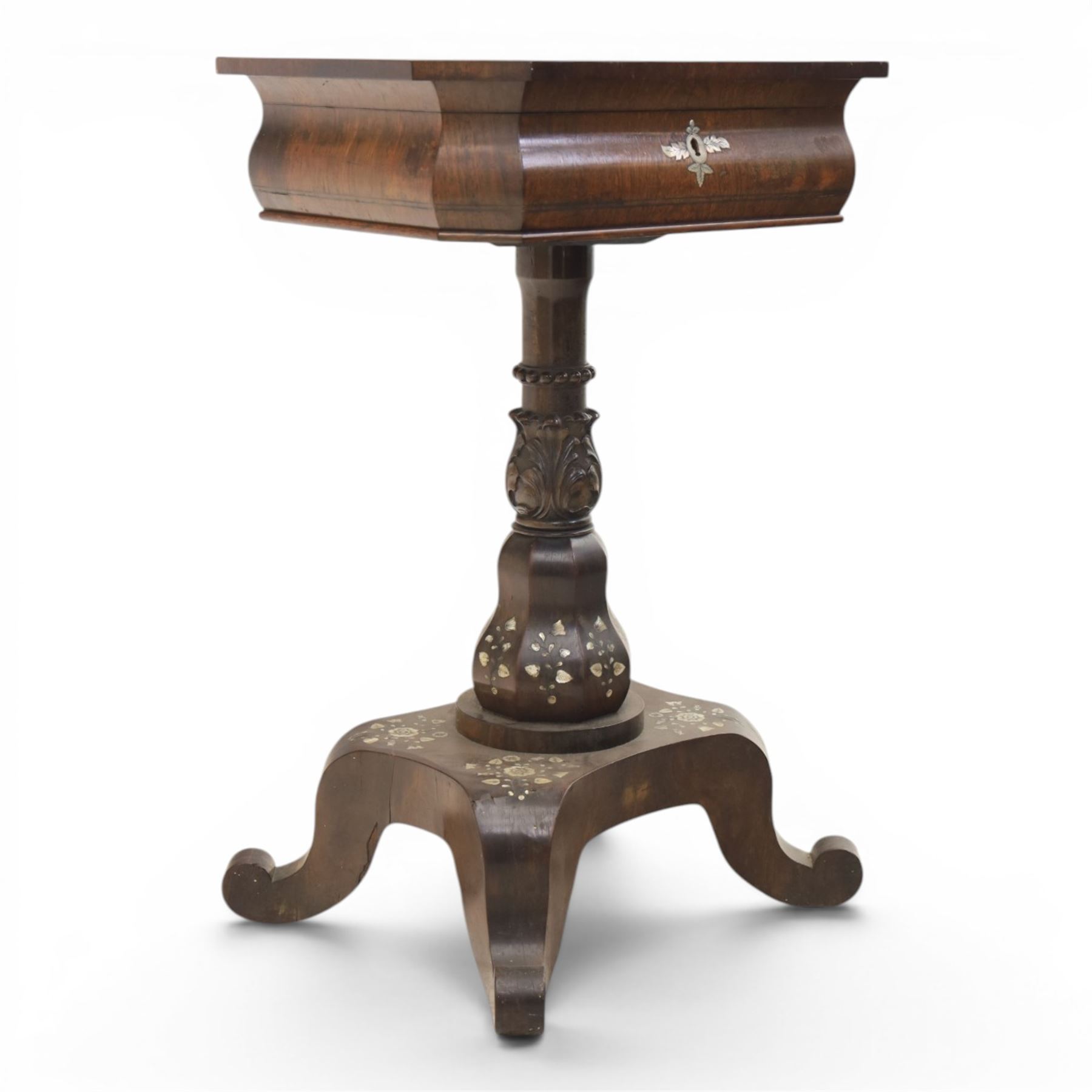 Victorian mahogany and mother-of-pearl inlaid work table, the octagonal hinged top enclosing a mirror and fitted compartmented interior, raised on a carved pedestal and quatriform platform base with scrolled feet