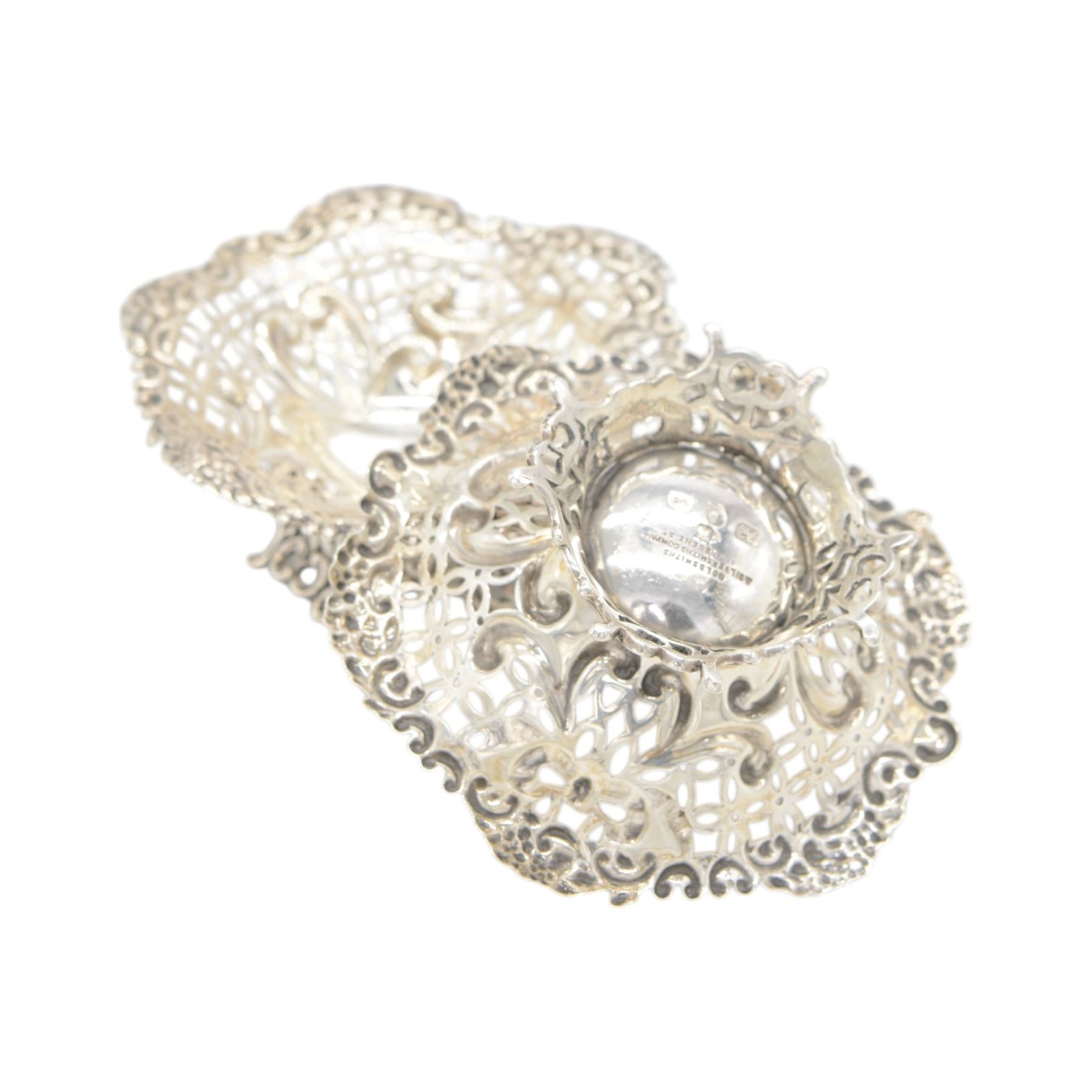 Pair of late Victorian silver bon bon dishes, of hexagonal form with embossed and pierced scrolling decoration, upon a circular pierced base, hallmarked Goldsmiths & Silversmiths Co, Birmingham 1893, W11cm, H4cm