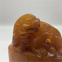 Chinese amber soapstone seal of oval form,  carved temple dog finial, inscription on the back and base, H12cm