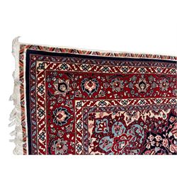 Persian Hamadan indigo ground rug, central floral crimson pole medallion surrounded by trailing foliate decoration and stylised plant motifs, the main guarded border with repeating stylised flower heads, densely knotted