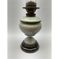 A Victorian oil lamp, with opaque glass reservoir hand painted with flowers beneath a Hinks burner and supporting a globular floral painted opaque glass shade and glass chimney, H47.5cm. 