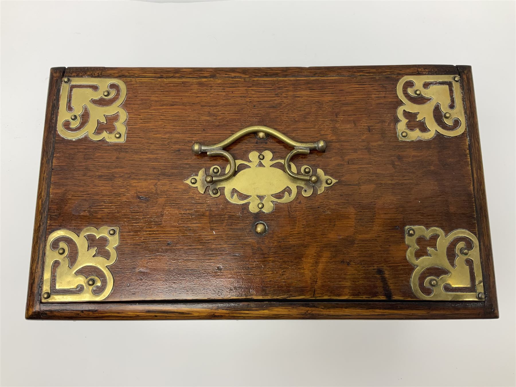 Brass mounted oak humidor, the slide action top opening to a base drawer, cedar lined with central compartment and striker, the drawer stamped Rd 107198, H17cm, D18cm