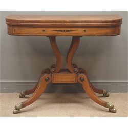  Regency mahogany card table, fold over swivel top with rosewood banding and scrolled inlay, baize lined, four serpentine pillar supports on platform, four splayed supports with brass claw cups and globular running castors, ebonised geometric inlays, W91cm, H74cm, D45cm  