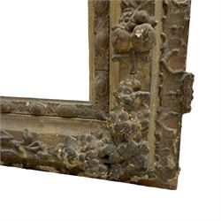 19th century giltwood and gesso moulded picture or mirror frame, the arched cresting rail mounted by central cartouche decorated with foliate scrolls and fruit, the outer frame decorated with scalloped edge and shell mouldings, trailing foliage with flower head and fruit to the central band, egg and dart moulded inner slip
