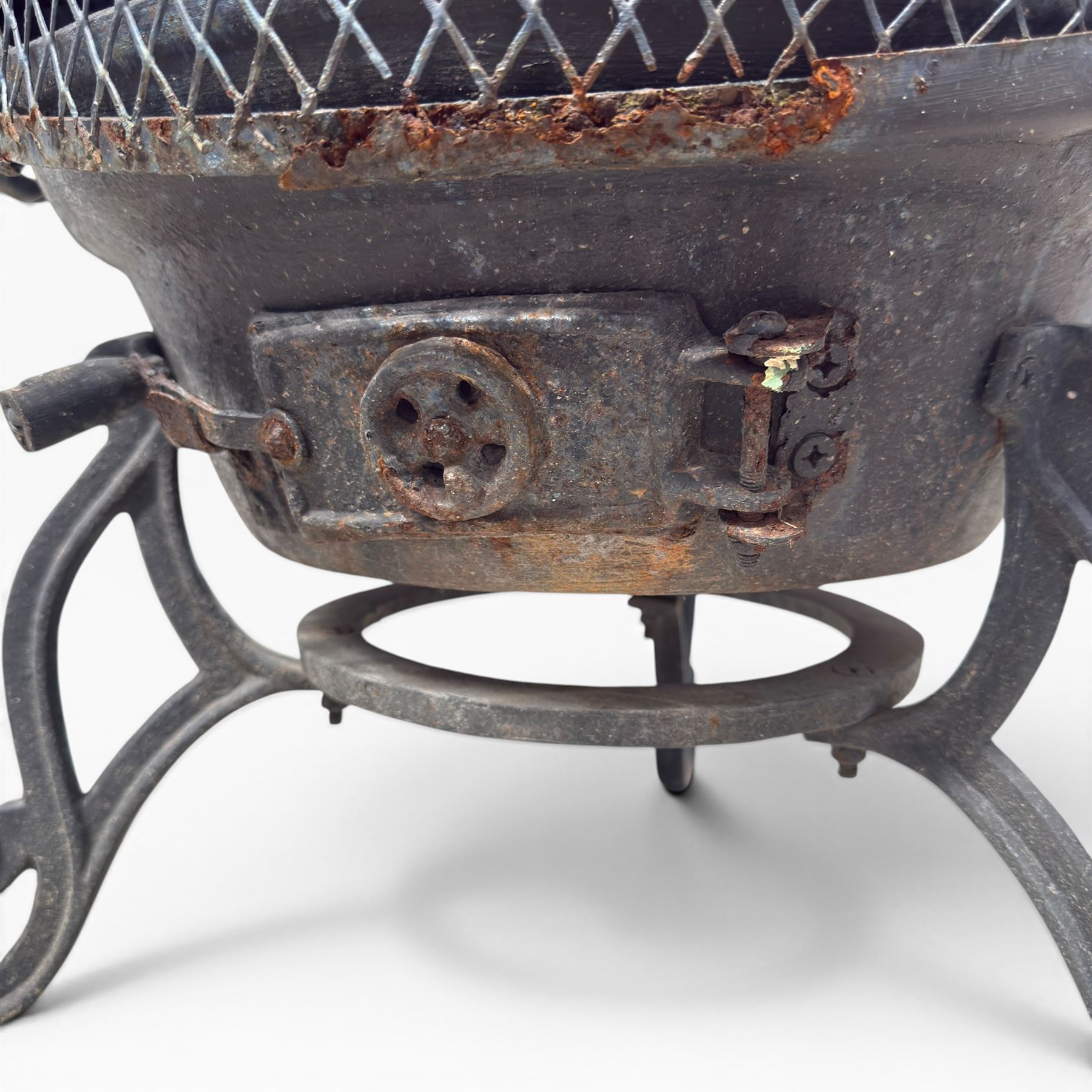 Cast iron garden chiminea, with mesh front spark guard, flue chimney on three splayed legs, finished in black.