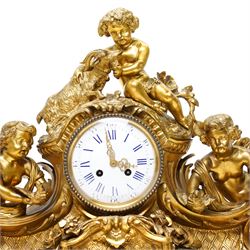 French-large late 19th-century 8-day Louis XV style gilt bronze mantel clock, with a cast rococo style case, elaborate C-scrolls, shells, and floral sprays, surmounted by a seated putto and goat symbolising pastoral love, flanked by two further seated putti on a scrolled foliate base, 5