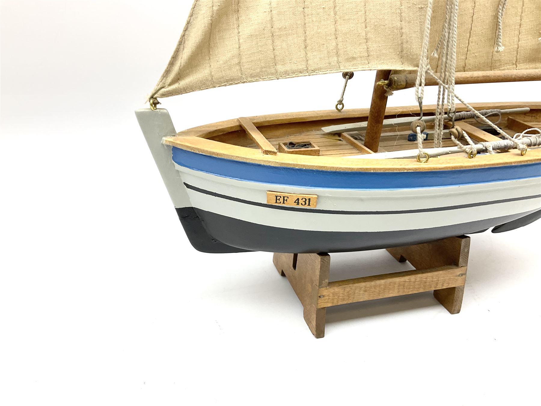 Wooden model of RMS Titanic, on a fixed black stand bearing plaque inscribed 'Titanic 1912', L54cm, H22cm, together with model of a sloop, gaff rigged on stand bearing plaque inscribed 'Sloop' L32cm, H42cm; and model of a fishing trawler on a stand bearing plaque inscribed 'Chalutier' L35cm, H28cm (3)