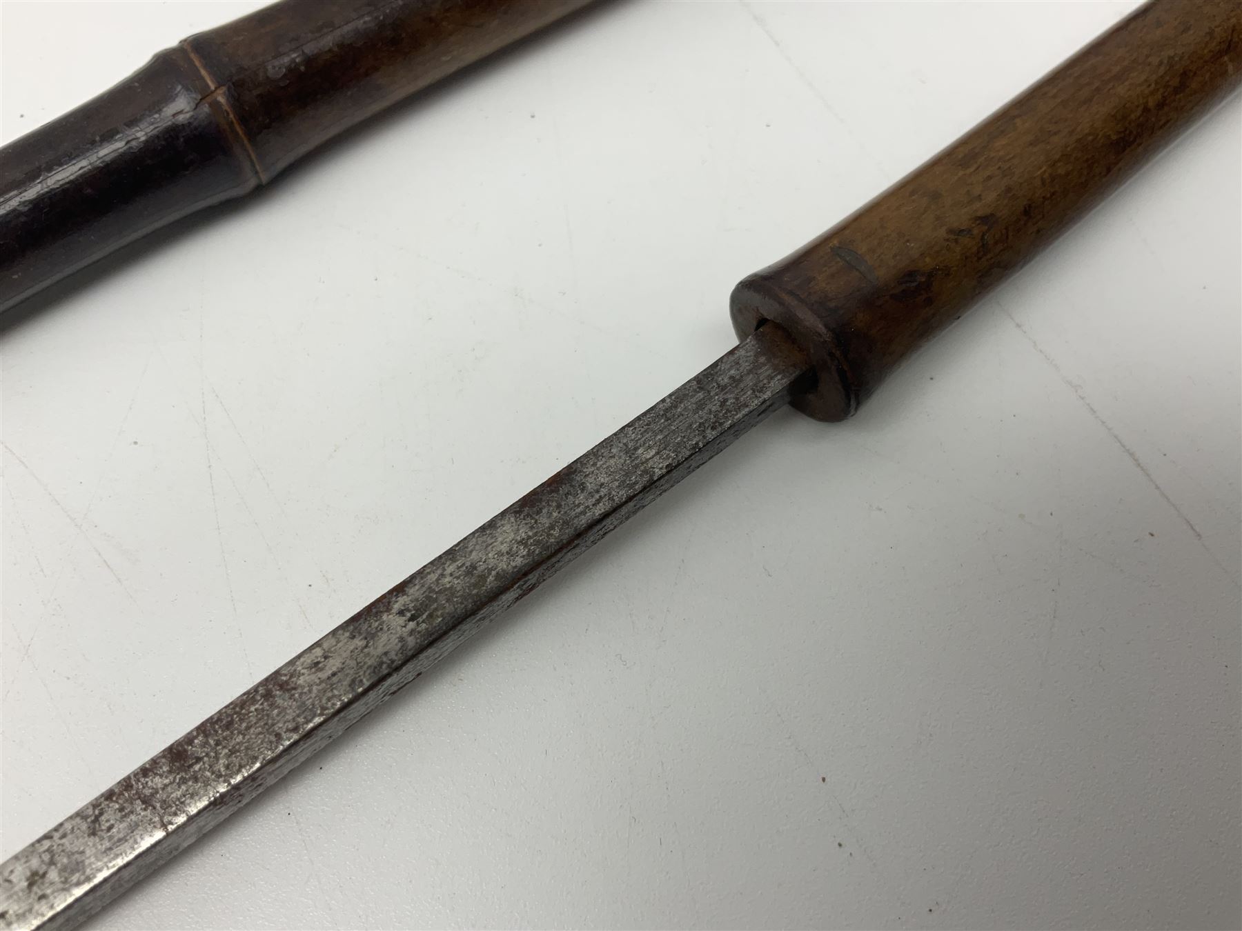 Early 20th century bamboo sword stick with 39cm oblong section blade L85cm overall; and two malacca cane swagger sticks, one with white metal mounts the other with yellow metal mounts (3)