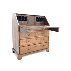 Georgian cross banded oak bureau, single fall front enclosing fitted interior with two sliding compartments disguised as leather bound books, four graduating drawers, bracket supports 