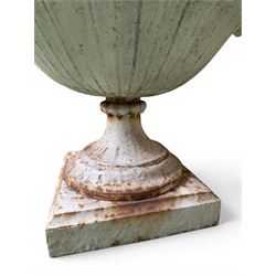 Coalbrookdale - pair of 19th century cast iron petal rim urns, squat form on square plinth, finished in distressed white paint, design registration number 133334, first registered 19 september 1860, number 19 in the Coalbrookdale Castings Catalogue (see illustration)