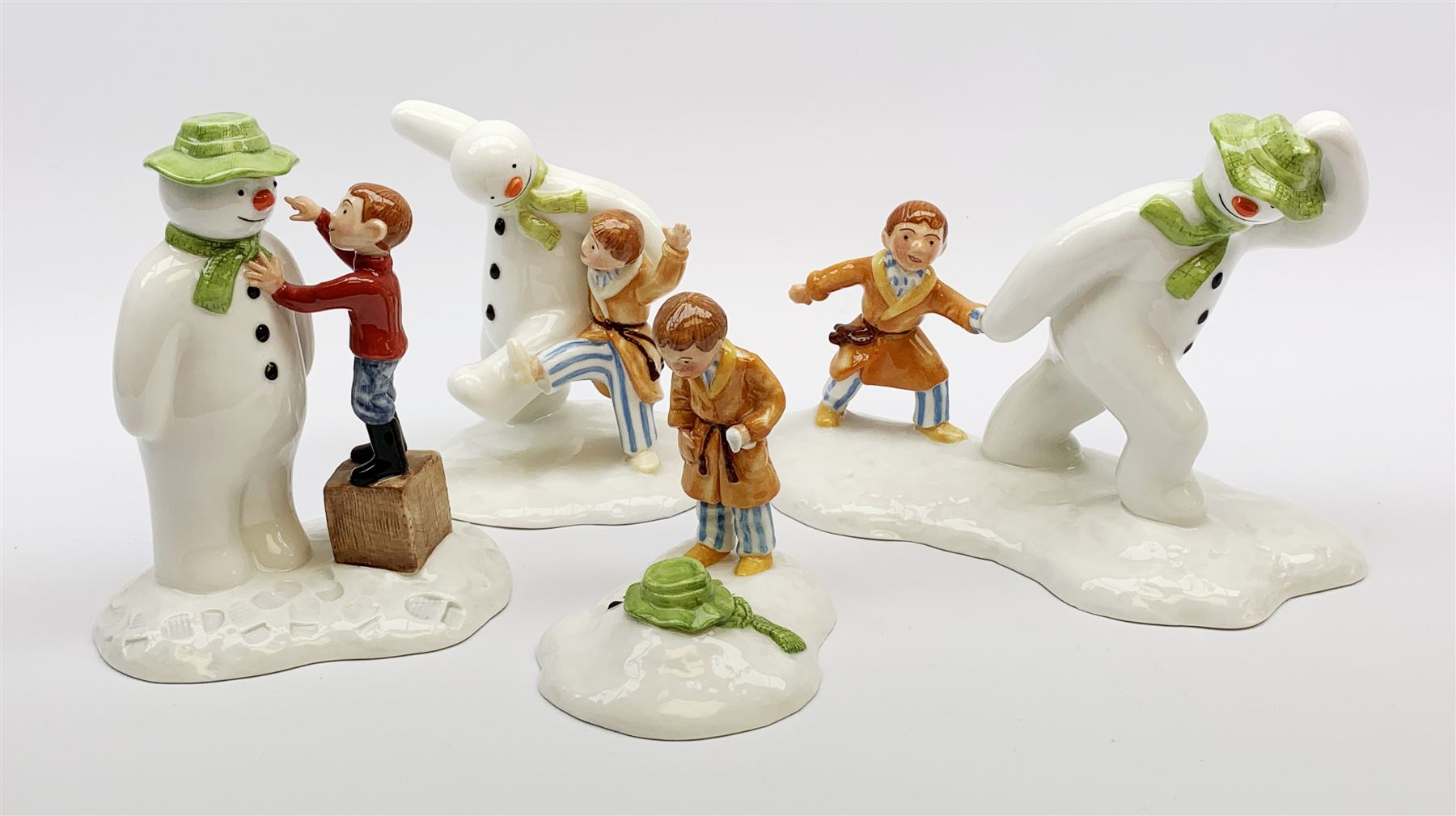 Four limited edition Royal Doulton The Snowman figures, comprising The Snowman and James dancing in the snow, 390/2,500, The Snowman and James Dressing the Snowman, 518/2,500, The Snowman and James The Adventure Begins, 1062/2,500, and The Snowman and James The Journey Ends, 693/2,500, each with accompanying certificate. 