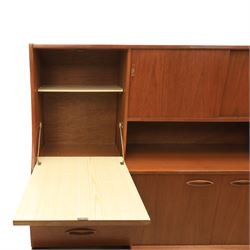 Jentique - mid-20th century teak highboard, fall front cabinet next to a sliding door cupboard above and open recess, the lower section with cabinet doors and three graduated drawers, raised on cylindrical legs
