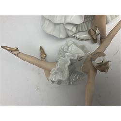 Two Wallendorf figures of ballerinas, the first modelled in extravagant dress seated with a mirror, no. 1396, the second in Swan Lake style dress in dramatic flying ballerina floor pose with her arms outstretched, no. 1694, both detailed with gilt and impressed and printed marks beneath, largest H25cm