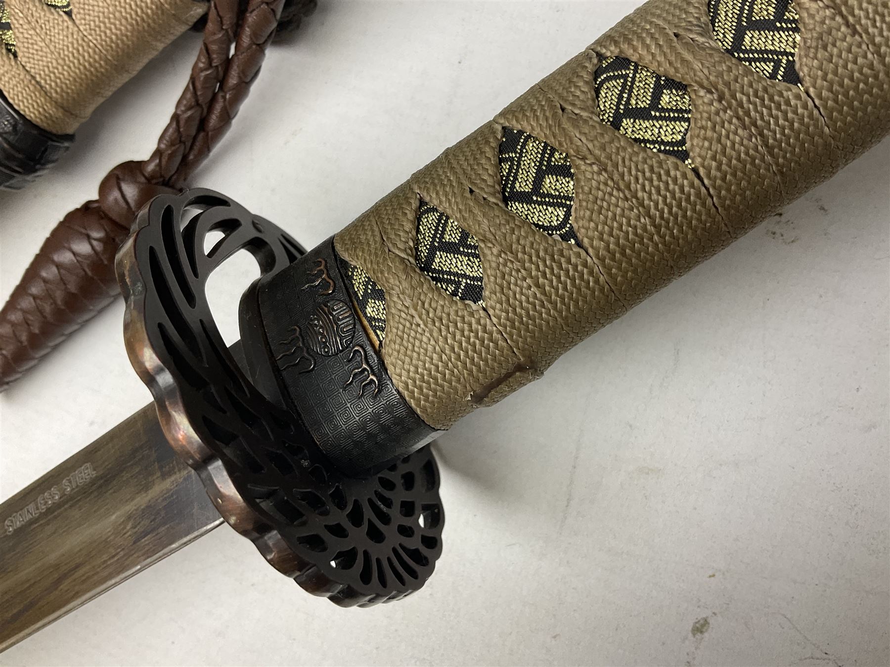 Reproduction Scottish officers basket hilt broad sword, the brass basket pierced with heart-shaped motifs lined with red lining, together with a reproduction Japanese Katana sword, longest L110cm