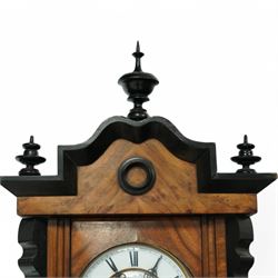 German- Late 19th century twin weight 8-day Vienna wall clock, in a walnut and ebonised case with turned finials and pendants, fully glazed door displaying the the brass cased weights and pendulum, enamel two-part dial with Roman numerals, minute rack, seconds hand and gothic steel hands, rack striking movement with a deadbeat escapement, striking the hours and half-hours on a coiled gong. With key.