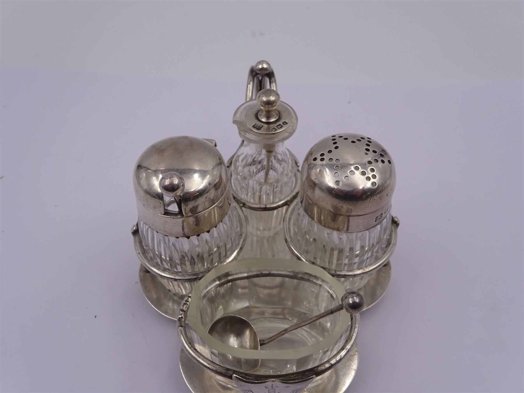 Late Victorian silver mounted four piece cut glass cruet set on stand, comprising pepper shaker, open salt, mustard pot and vinegar bottle, the silver stand with shield engraved with the Workman family crest, hallmarked Hukin & Heath, London 1899, including bottles H7cm
