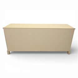 Contemporary French design white painted bedroom suite retailed by Barkers of Northallerton, comprising wide chest fitted with four short and four long drawers with oval brass handles (H 70cm, W 159cm, D 46cm), pair of bedside chests each fitted with three drawers (H 62cm, W 40cm, D 46cm), dressing table fitted with four short drawers and central kneehole with shaped apron (H 79cm, W 131cm, D 46cm) with matching framed wall mounted mirror (H 100cm, W 113cm), and full length standing mirror (H 175cm, W 73cm)