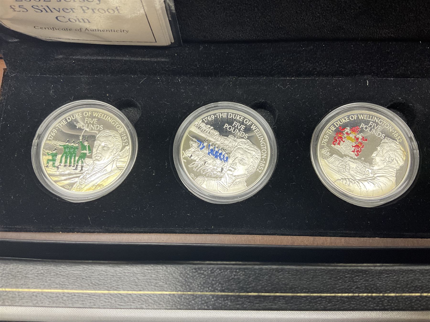 The Royal Mint United Kingdom 1977 silver proof two coin set, Queen Elizabeth II 2002 silver proof three coin set, comprising Bailiwick of Jersey, Bailiwick of Guernsey, and Alderney five pound coins, 'First Coinage of the British Virgin Islands' proof set, 1997 1/10 ounce fine silver Britannia, two King George V 1935 'Rocking Horse' crowns, various Isle of Man commemorative crowns, etc., house in a hard shell carry case